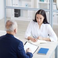 High angle portrait of young woman answering questions during job interview in office, copy space